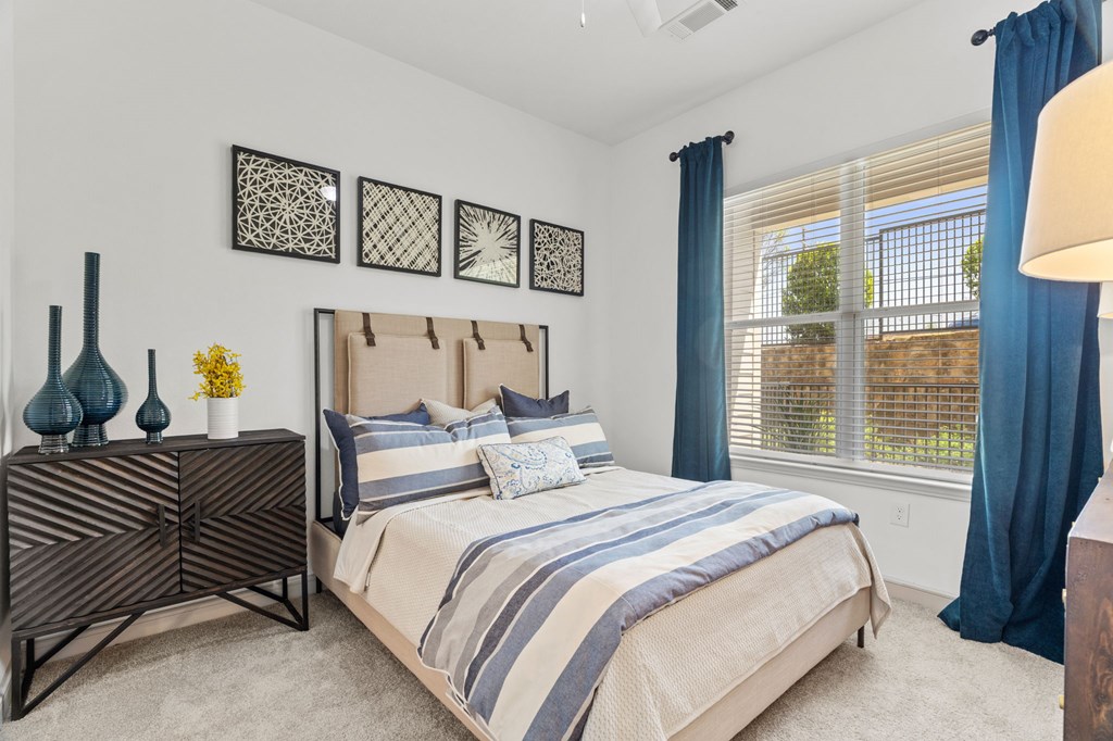 A bedroom with a large bed and a wooden dresser.