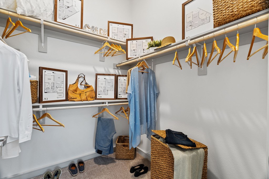 A white wall with clothes hanging on hangers.