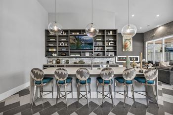 a kitchen with a long island with a bunch of stools in front of it