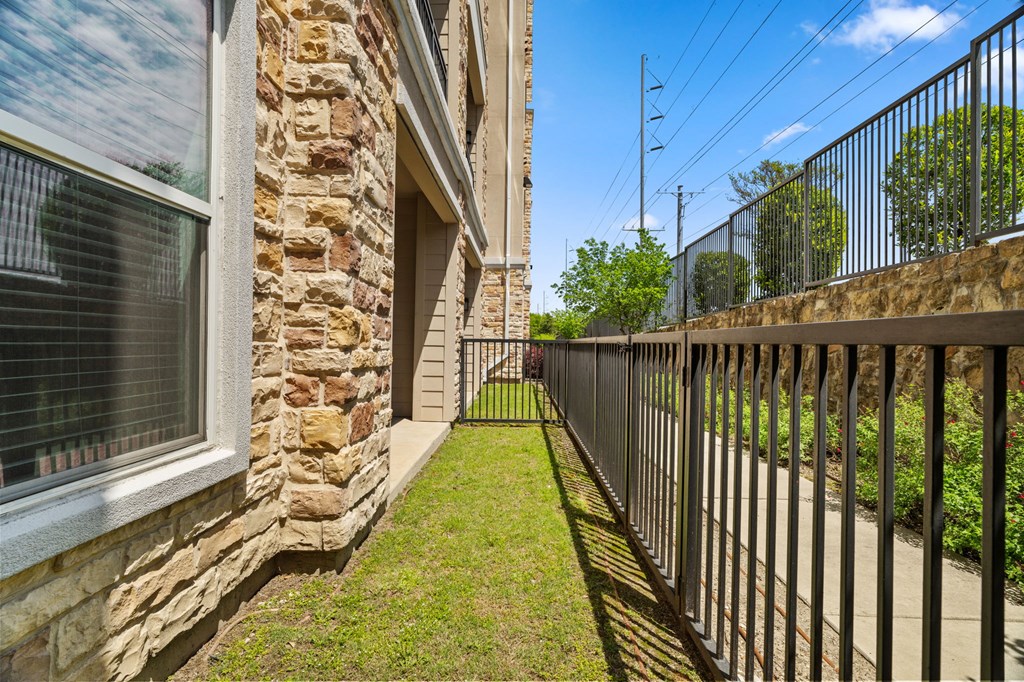 A stone building with a black iron fence in front.