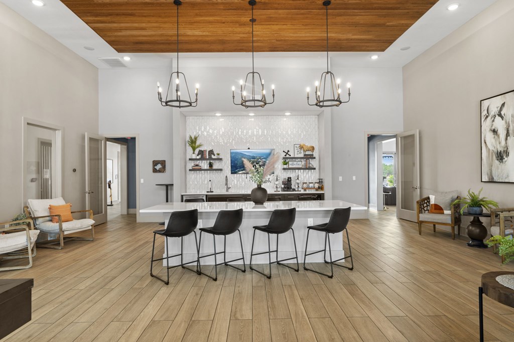 A modern dining room with a wooden floor and a large painting on the wall.