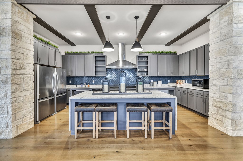 a large kitchen with a blue island and stainless steel appliances