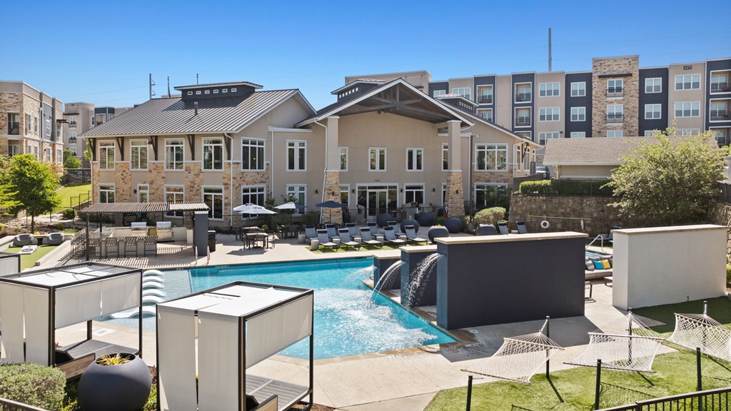 A large building with a pool in front of it.