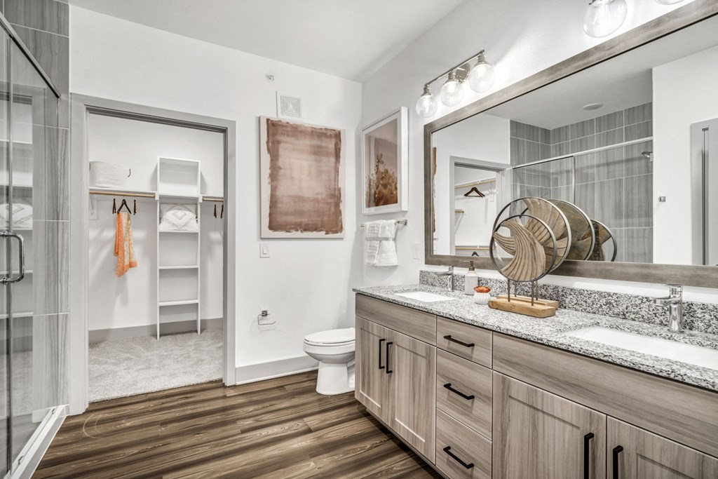 a bathroom with a large mirror and a toilet and a shower
