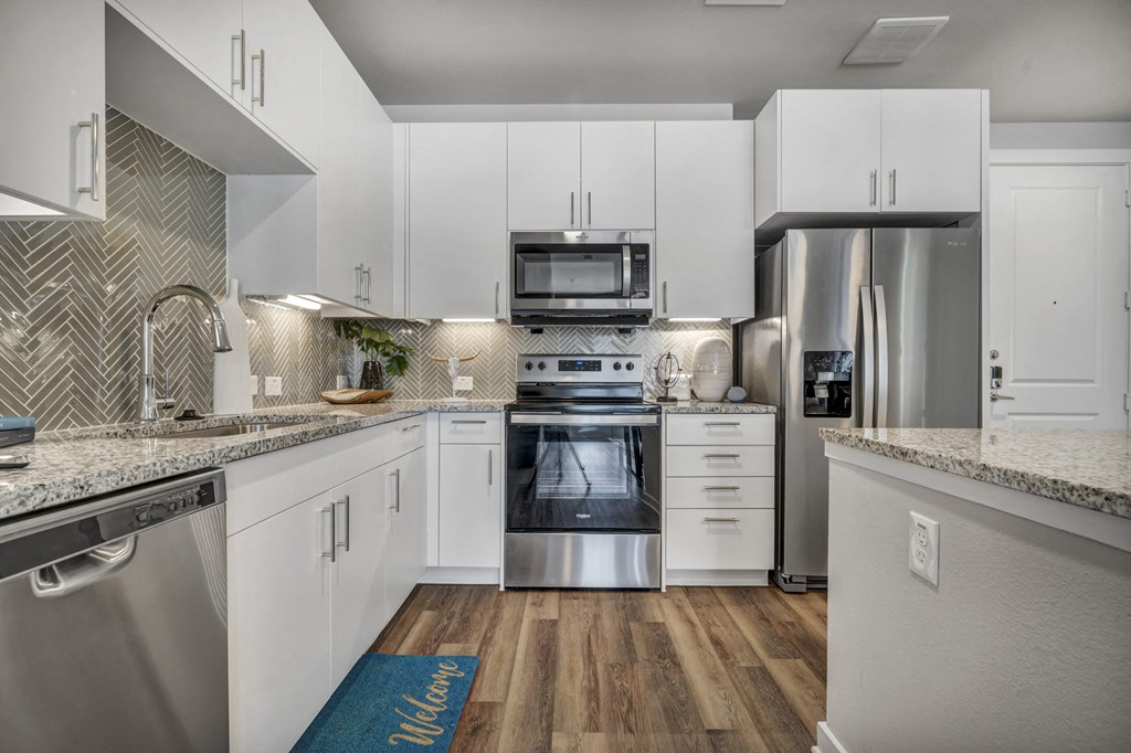 a kitchen with white cabinets and stainless steel appliances