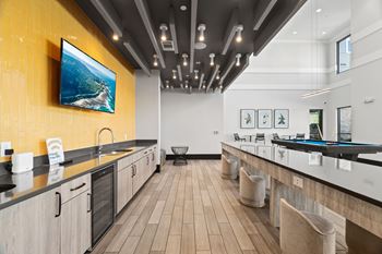 A modern kitchen with a long counter and a painting hanging above it.