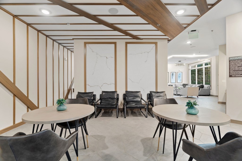 A room with a white table and black chairs.