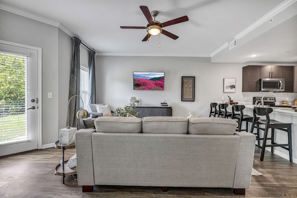 a living room with a couch and a ceiling fan