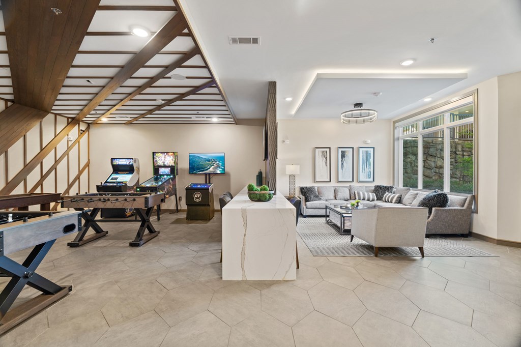 A living room with a wooden ceiling and a grey sofa.