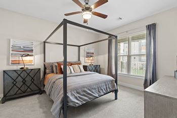 a bedroom with a four poster bed and a ceiling fan