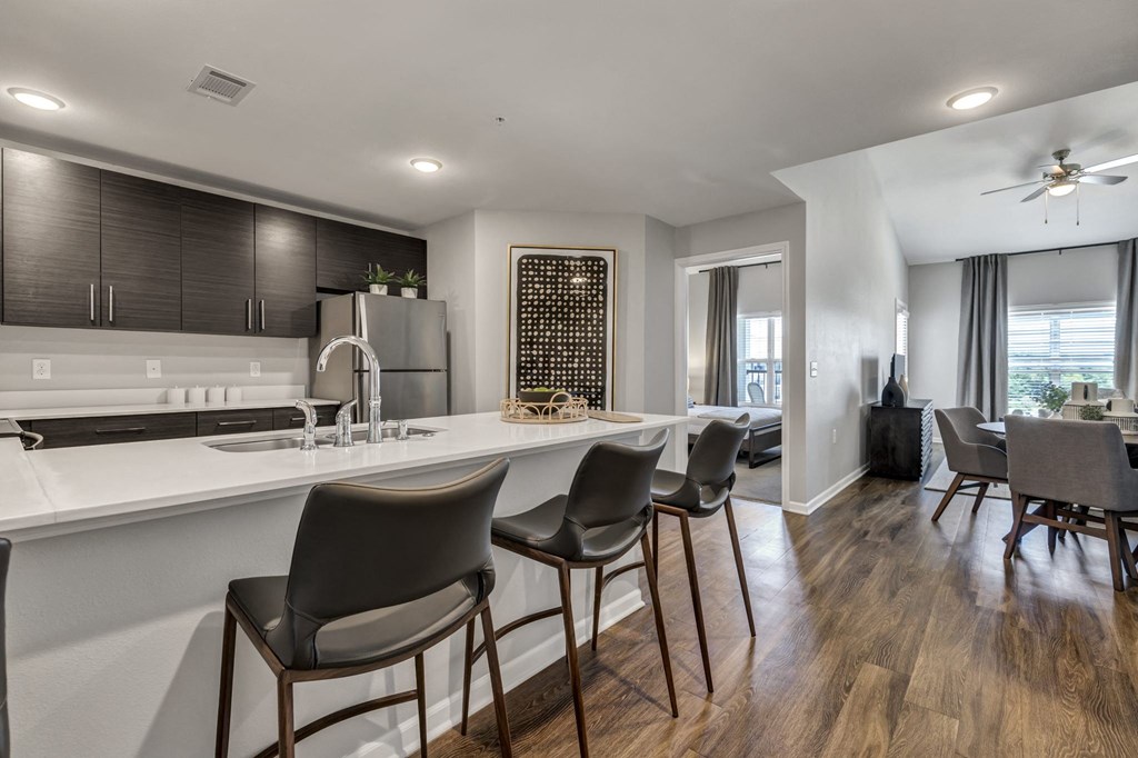 a kitchen with a bar and chairs next to a living room