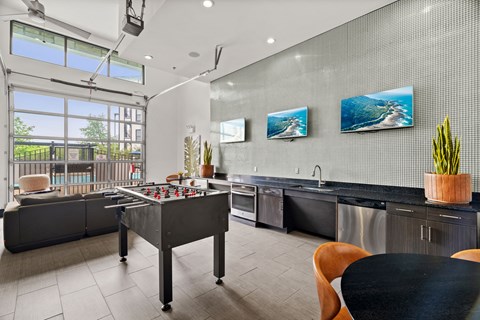 A modern kitchen with a black table and chairs.