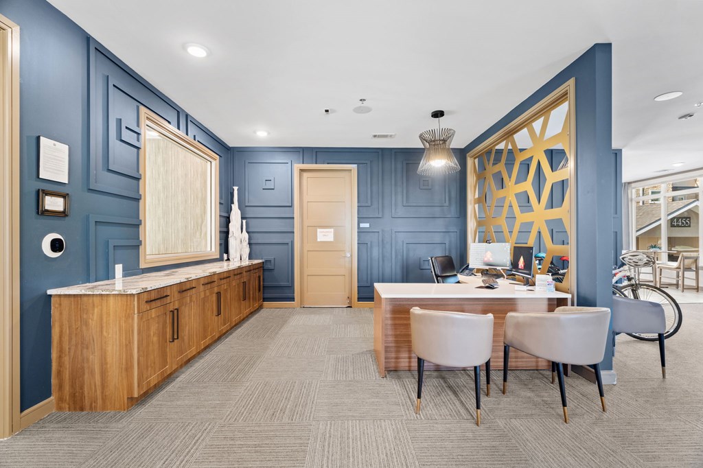 A room with a table and chairs in the foreground and a blue wall in the background.