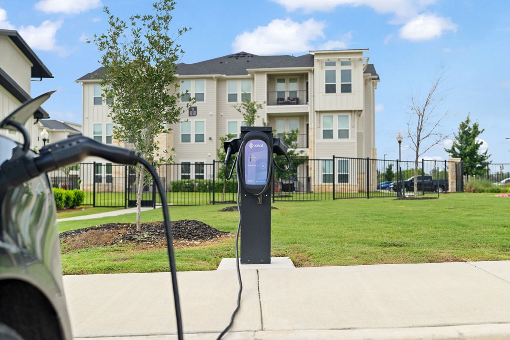 A black electric vehicle charging station is plugged into a car.