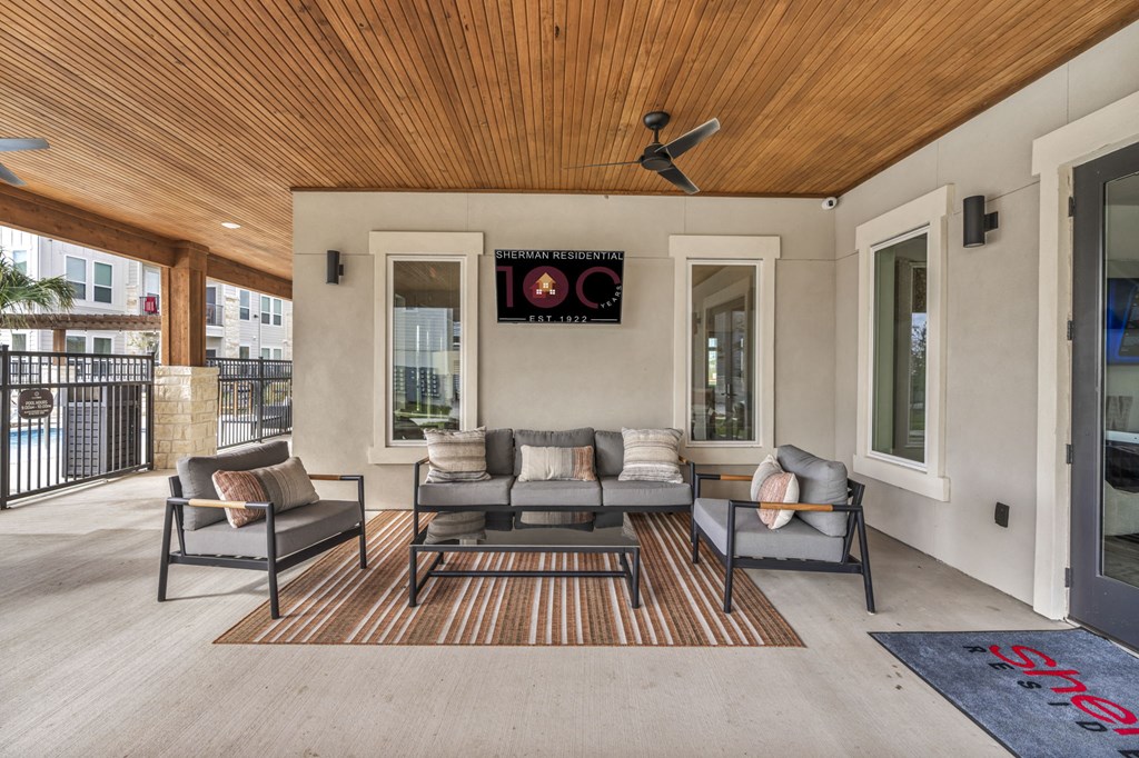 a covered patio with couches and chairs and a ceiling fan