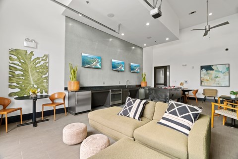 A living room with a couch, chairs, and a kitchen area in the background.