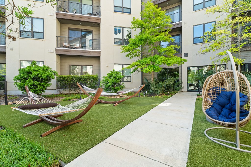 A modern outdoor patio area with a hammock and a swing.