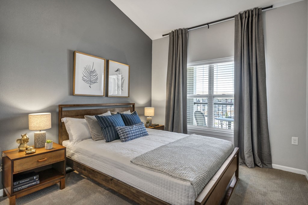 bedroom with a large window and a bed with pillows