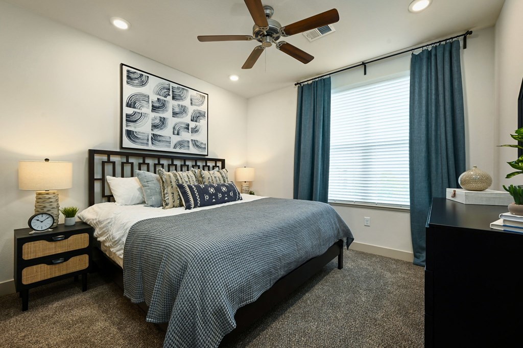 a bedroom with a bed and a ceiling fan