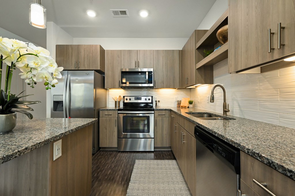 a modern kitchen with stainless steel appliances and granite counter tops