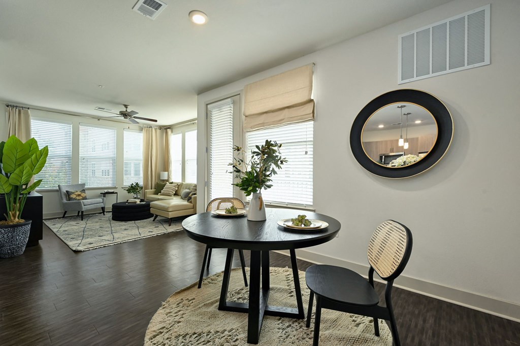a living room with a round table and a mirror on the wall