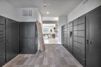 a row of black lockers in a room with a staircase in the background