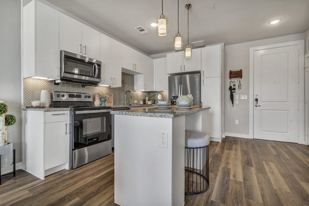 a kitchen with white cabinets and stainless steel appliances