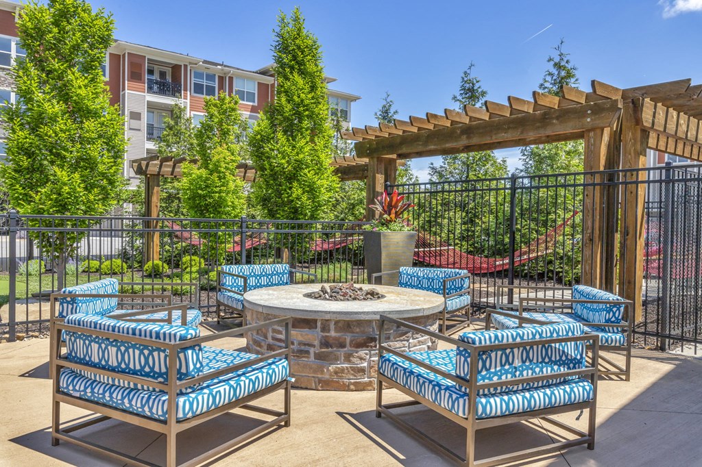 our patio has a fire pit and blue and white chairs