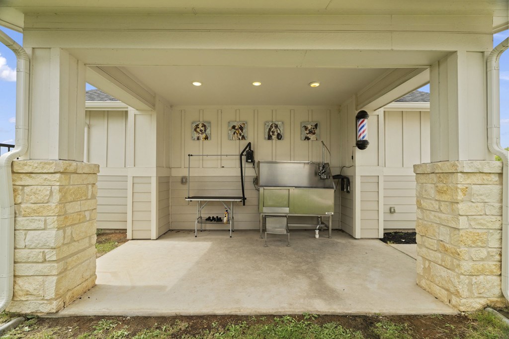 A barber shop with a white exterior and a concrete floor.