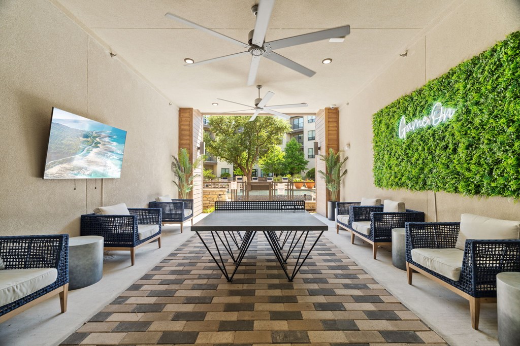 A patio with a table, chairs, and a green wall with the word "Garden" on it.
