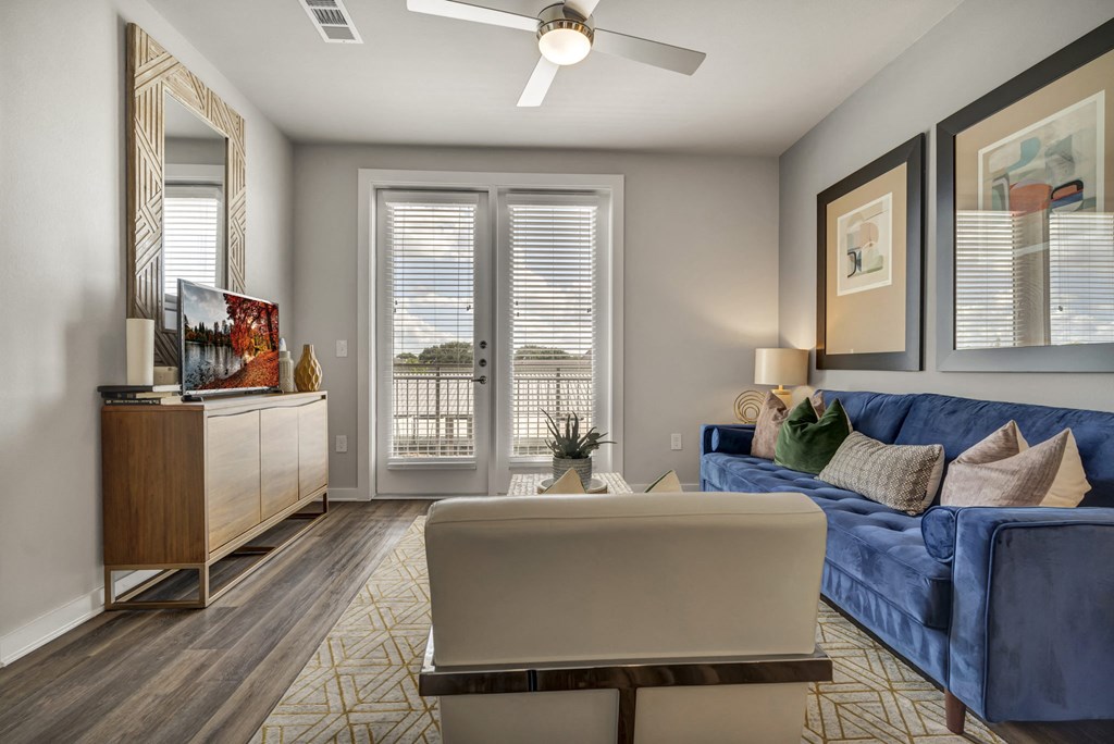 a living room with a blue couch and a ceiling fan