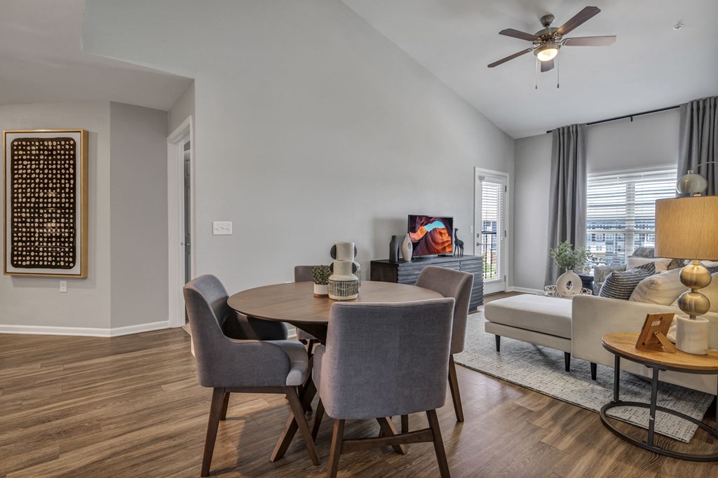 a living room with a dining room table and a ceiling fan