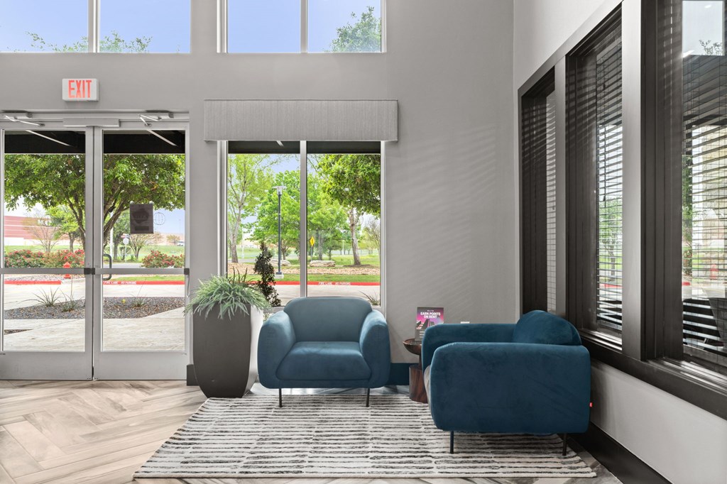 A waiting area with blue chairs and a potted plant.