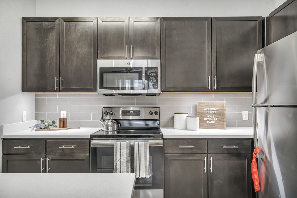 a kitchen with stainless steel appliances and black cabinets