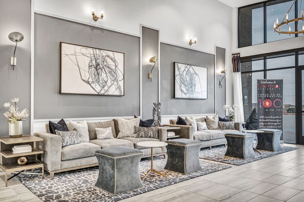 a living room with couches and tables and large windows