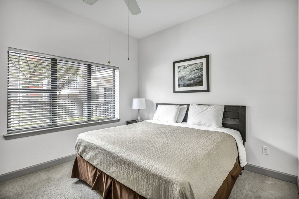 a bedroom with a bed and a large window