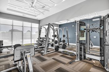 a workout room with exercise machines and a large window