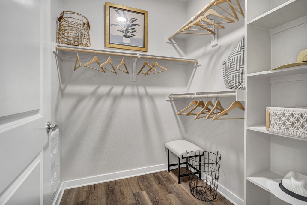 a walk in closet with shelves and a chair