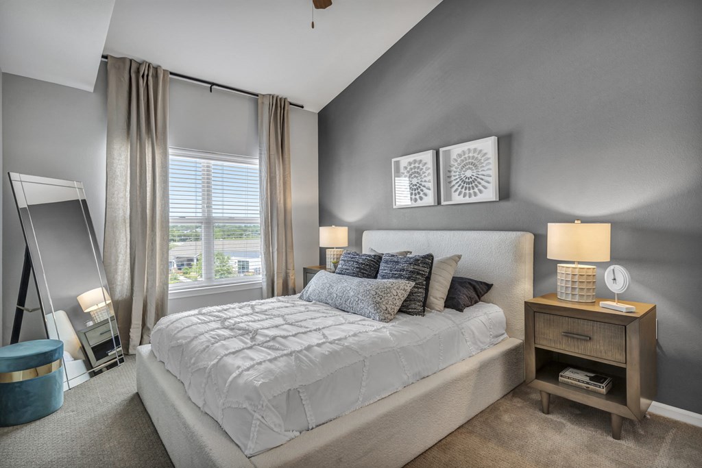 a bedroom with a bed and a large window