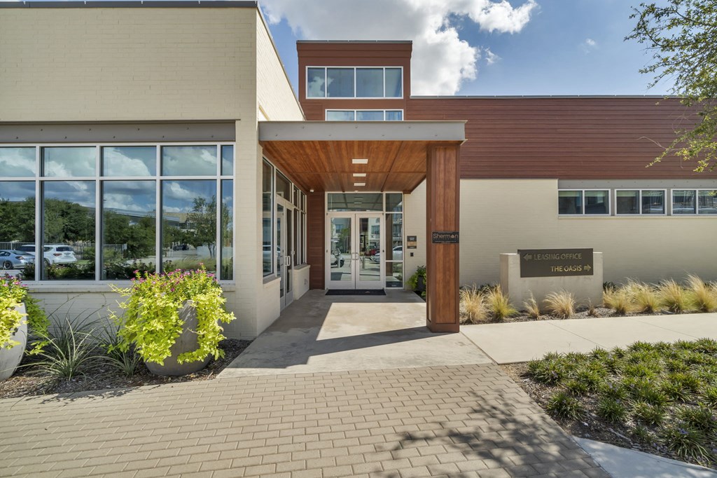the front entrance of a building with large windows and a walkway