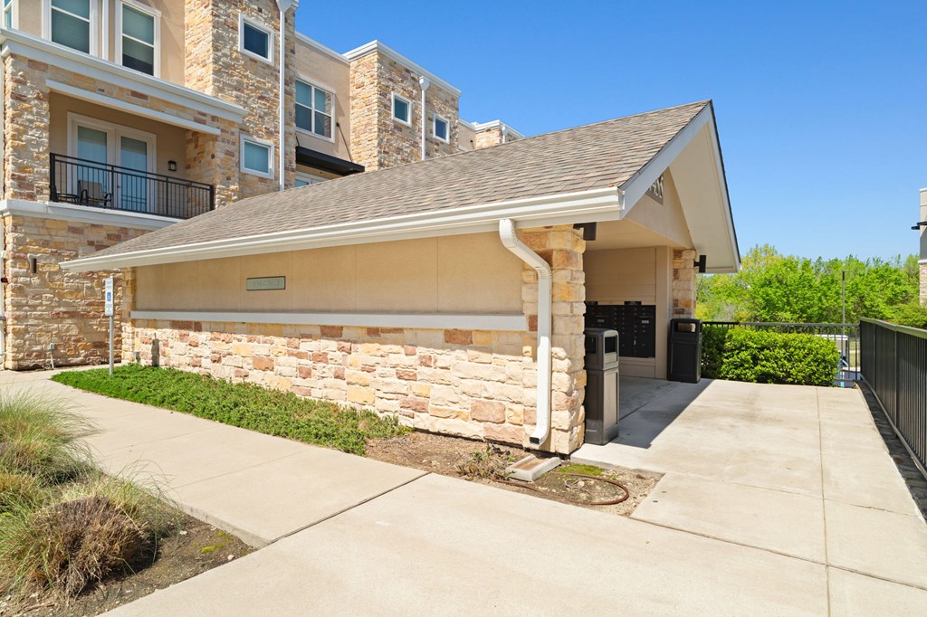 A modern house with a stone wall and a covered entrance.