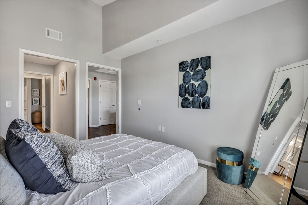 a bedroom with a large bed and a painting on the wall