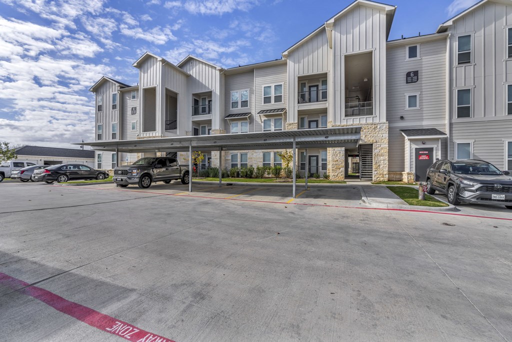 an empty parking lot in front of an apartment building