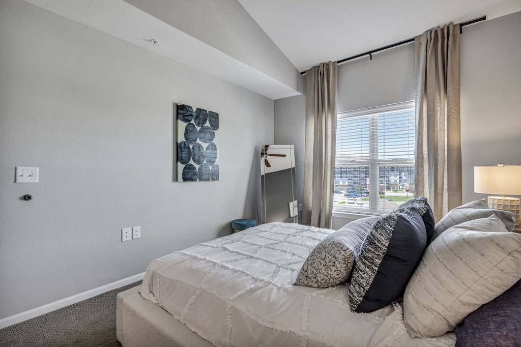 a bedroom with a large bed and a window