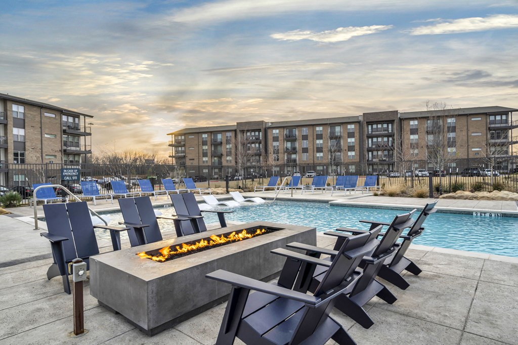 an outdoor patio with chairs and a fire pit and a pool