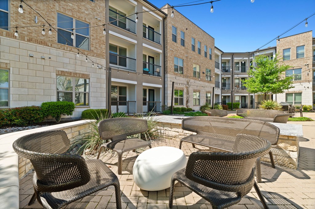 A patio with chairs and a table in front of a building.