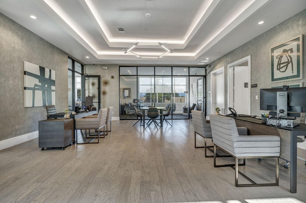 a large lobby with chairs and tables and a tv