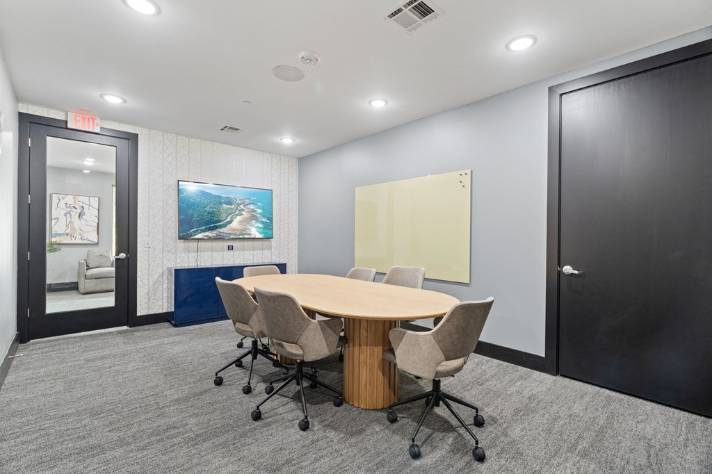 A conference room with a large table and chairs.