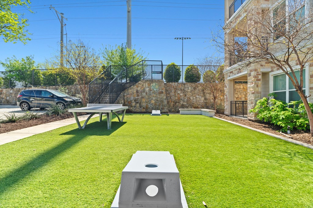 A backyard with a picnic table and a concrete block with a hole in the middle.