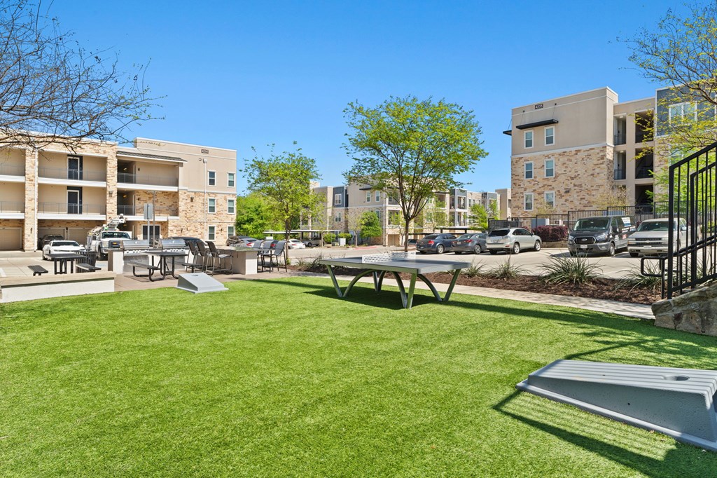 A sunny day at the park with a bench and a picnic table.